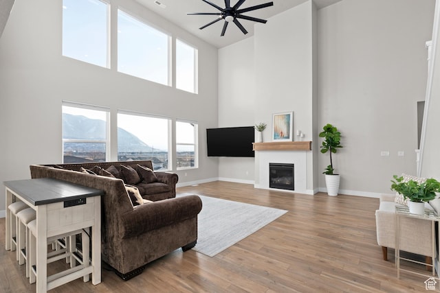 833 N Union Bench Dr W Unit 62, Mapleton, UT 84664 - living room featuring a high ceiling, baseboards, a glass covered fireplace, wood finished floors, and a ceiling fan