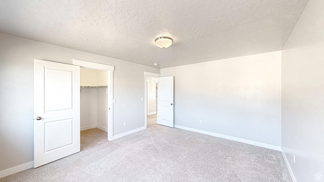 833 N Union Bench Dr W Unit 62, Mapleton, UT 84664 - unfurnished bedroom with baseboards, carpet floors, a walk in closet, a textured ceiling, and a closet