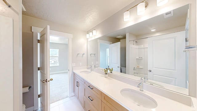 833 N Union Bench Dr W Unit 62, Mapleton, UT 84664 - full bathroom featuring toilet, double vanity, a textured ceiling, tile patterned flooring, and a shower