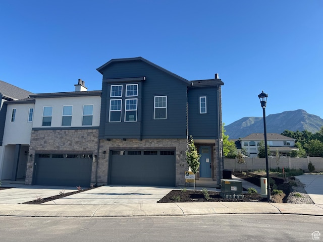 322 W Songbird Ln N Unit 24, Lindon, UT 84042 - view of front of house featuring a mountain view, concrete driveway, stone siding, a garage, and a chimney