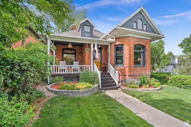 237 E 4th Ave N, Salt Lake City, UT 84103 - view of front of home with brick siding, a front yard, covered porch, and roof with shingles