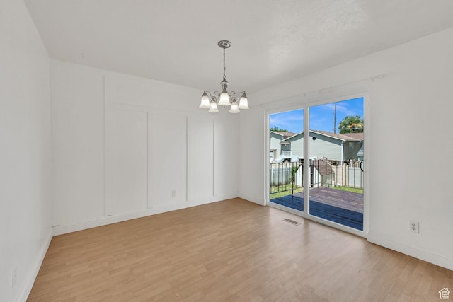 2652 W 6050 S, Roy, UT 84067 - spare room featuring light wood-style floors, a chandelier, and baseboards