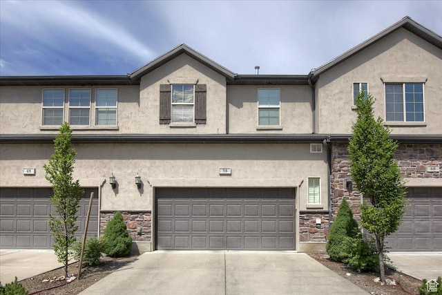 58 N 285 W, Centerville, UT 84014 - view of front of house with stone siding, stucco siding, an attached garage, and concrete driveway