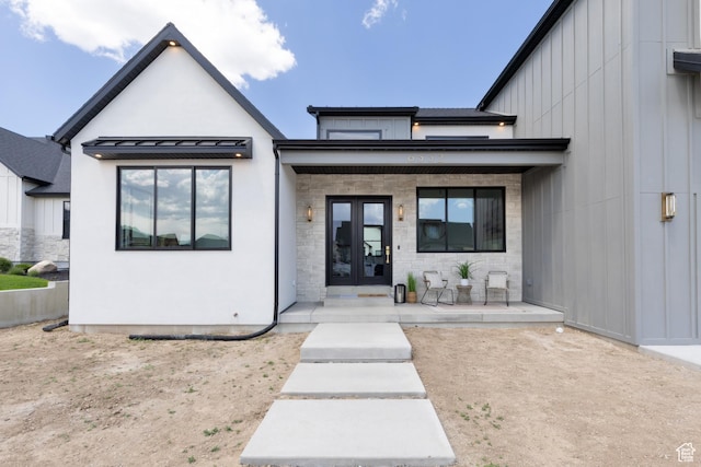 6552 W Timber Ranch Dr, Herriman, UT 84096 - view of front facade featuring french doors, a porch, board and batten siding, a standing seam roof, and stucco siding