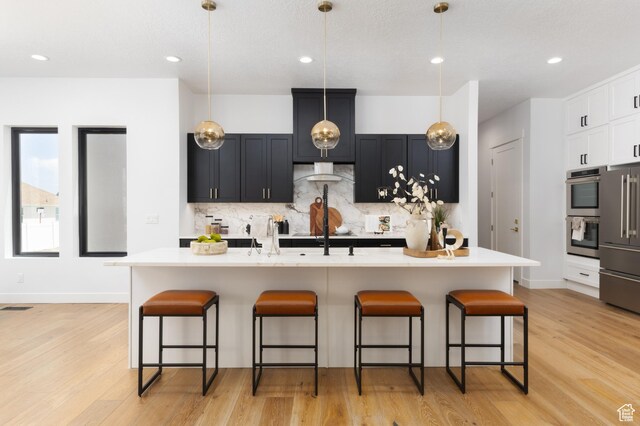 6552 W Timber Ranch Dr, Herriman, UT 84096 - kitchen featuring stainless steel appliances, decorative backsplash, a kitchen bar, light countertops, and recessed lighting