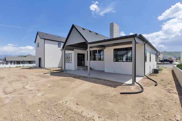 6552 W Timber Ranch Dr, Herriman, UT 84096 - rear view of house featuring a chimney, a patio, central air condition unit, and board and batten siding
