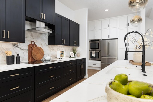 6552 W Timber Ranch Dr, Herriman, UT 84096 - kitchen featuring appliances with stainless steel finishes, dark cabinets, extractor fan, white cabinets, and light stone countertops