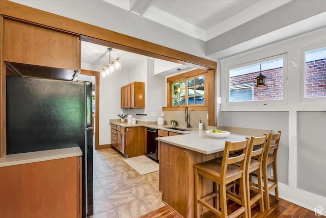 457 S Douglas St E, Salt Lake City, UT 84102 - kitchen with a sink, black appliances, brown cabinets, a peninsula, and light countertops