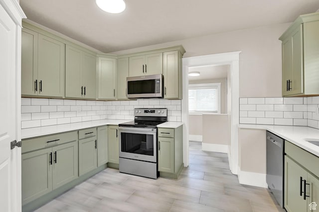 2654 Brinker Ave, Ogden, UT 84401 - kitchen with appliances with stainless steel finishes, green cabinets, light countertops, and tasteful backsplash