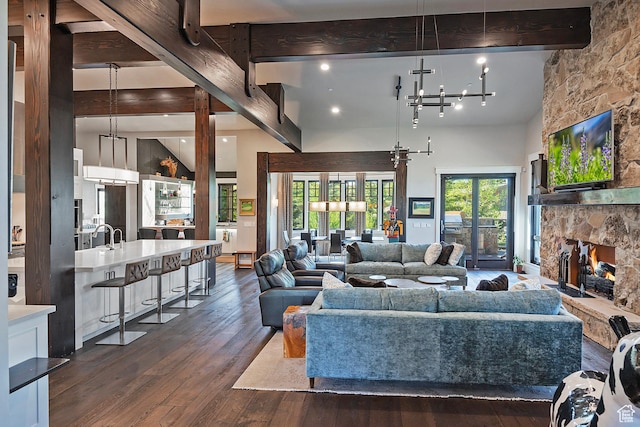 3428 Westview Trl, Park City, UT 84098 - living area featuring beamed ceiling, dark wood-style flooring, a stone fireplace, a towering ceiling, and a chandelier