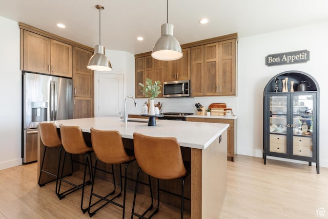 611 E 400 N, Providence, UT 84332 - kitchen featuring appliances with stainless steel finishes, tasteful backsplash, light wood-type flooring, brown cabinetry, and recessed lighting
