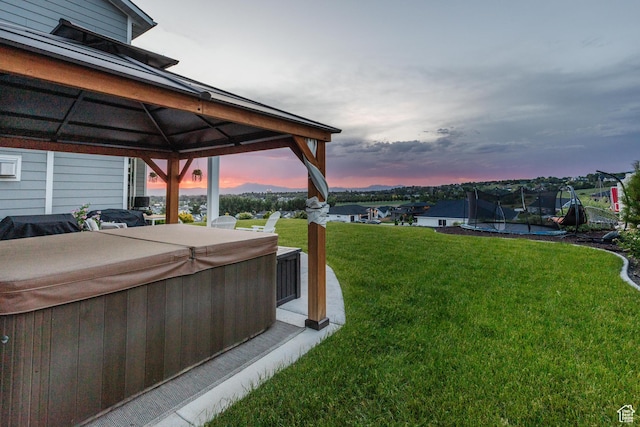 611 E 400 N, Providence, UT 84332 - yard at dusk featuring a hot tub, a gazebo, a trampoline, and a yard