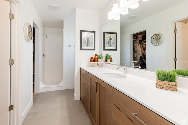 611 E 400 N, Providence, UT 84332 - bathroom with vanity, a shower stall, a walk in closet, and baseboards