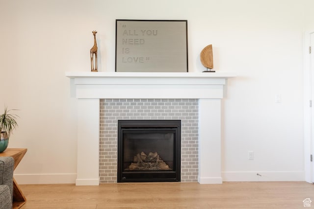611 E 400 N, Providence, UT 84332 - detailed view of a glass covered fireplace, baseboards, and wood finished floors