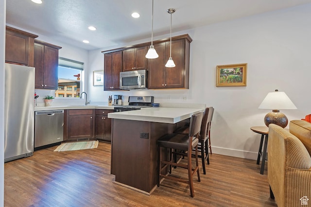 1370 Center Dr Unit 17, Kimball Junction, UT 84098 - kitchen with appliances with stainless steel finishes, a peninsula, a breakfast bar, a sink, and dark wood-type flooring