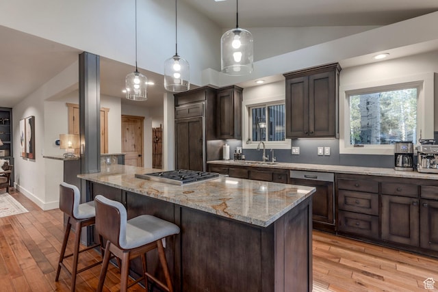2126 Twilight Ct, Park City, UT 84060 - kitchen with stainless steel gas cooktop, dark brown cabinetry, a sink, light wood-type flooring, and a breakfast bar