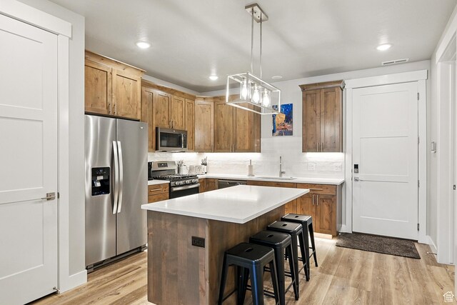 899 S Lincoln Ave Unit 3, Cedar City, UT 84720 - kitchen featuring appliances with stainless steel finishes, a sink, light wood finished floors, a kitchen breakfast bar, and a center island