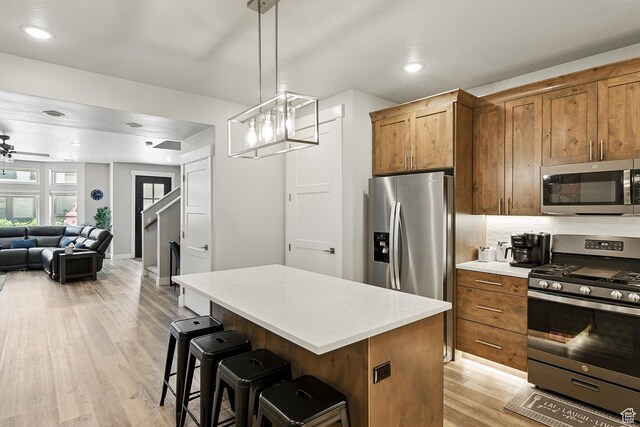 899 S Lincoln Ave Unit 3, Cedar City, UT 84720 - kitchen featuring appliances with stainless steel finishes, light wood finished floors, open floor plan, a center island, and light countertops