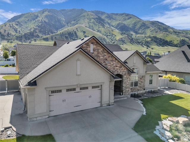 1872 N 1850 E, North Logan, UT 84341 - view of front facade featuring stucco siding, a mountain view, a shingled roof, and stone siding