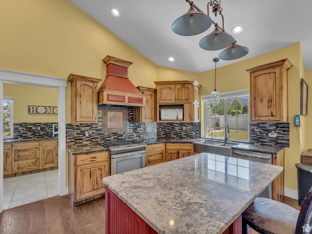 1872 N 1850 E, North Logan, UT 84341 - kitchen featuring appliances with stainless steel finishes, a sink, lofted ceiling, decorative backsplash, and a kitchen island