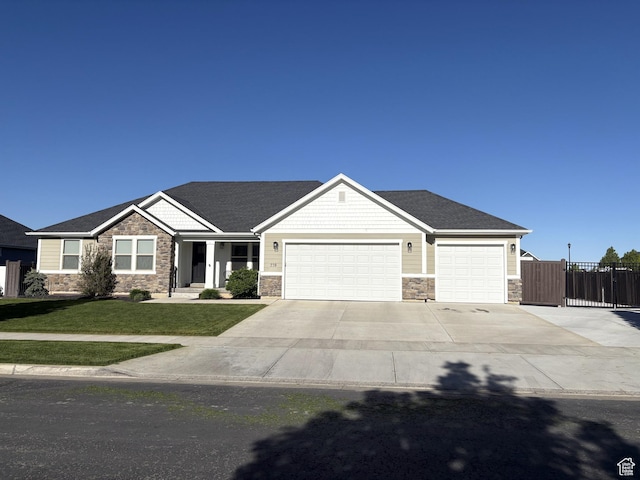 239 N 2400 E, Spanish Fork, UT 84660 - craftsman-style home with stone siding, a garage, concrete driveway, and a shingled roof