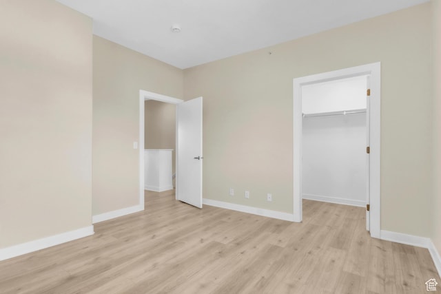 185 W 700 S Unit 101, Salt Lake City, UT 84101 - unfurnished bedroom with light wood-style flooring, a walk in closet, baseboards, and a closet