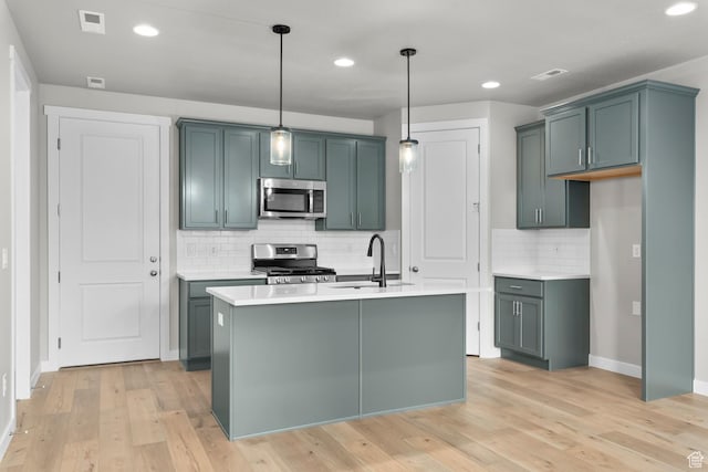 746 W Signal Dr, Salt Lake City, UT 84123 - kitchen featuring stainless steel appliances, a sink, decorative backsplash, light countertops, and pendant lighting