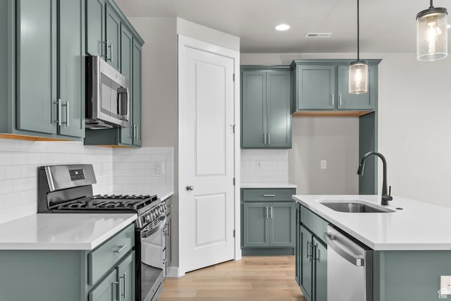 746 W Signal Dr, Salt Lake City, UT 84123 - kitchen featuring appliances with stainless steel finishes, a sink, light wood-style flooring, hanging light fixtures, and light countertops