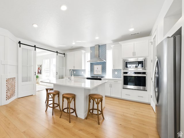 6034 W Sparrow View Dr, South Jordan, UT 84009 - kitchen with appliances with stainless steel finishes, wall chimney exhaust hood, a kitchen breakfast bar, white cabinets, and recessed lighting