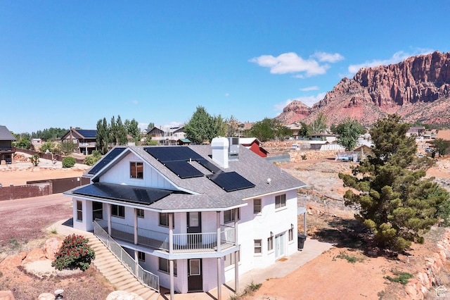 740 W Uzona Ave, Hildale, UT 84784 - back of property featuring a balcony, solar panels, a chimney, roof with shingles, and a mountain view