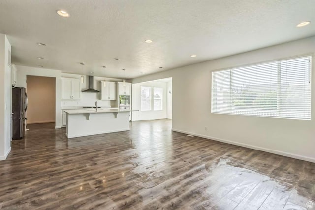 2199 W 650 S, Lehi, UT 84043 - unfurnished living room featuring a sink, dark wood-type flooring, baseboards, recessed lighting, and a textured ceiling