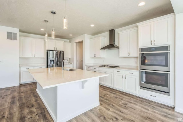 2199 W 650 S, Lehi, UT 84043 - kitchen featuring wall chimney range hood, appliances with stainless steel finishes, a sink, white cabinetry, and dark wood-style flooring