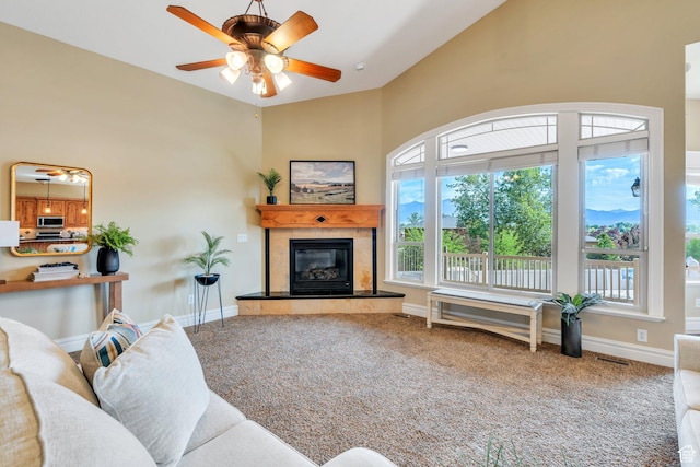 2632 S 2975 W, West Haven, UT 84401 - carpeted living area with a tiled fireplace, healthy amount of natural light, a ceiling fan, baseboards, and a towering ceiling