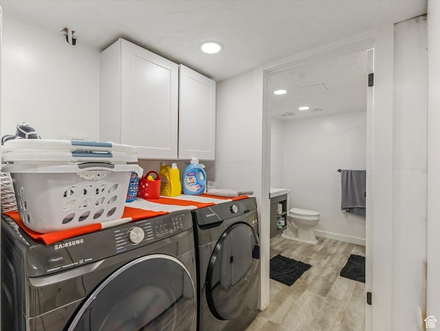 3951 S 875 E Unit 25, Ogden, UT 84403 - laundry area featuring cabinet space, washer and clothes dryer, light wood-style floors, and baseboards