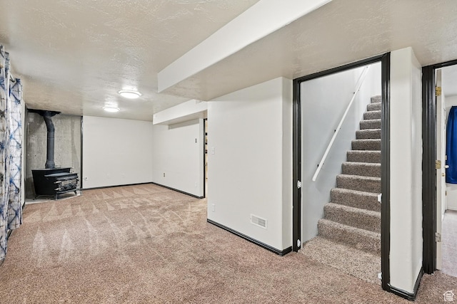 1790 E Homestead, Enoch, UT 84721 - finished basement with carpet floors, stairway, baseboards, a wood stove, and a textured ceiling