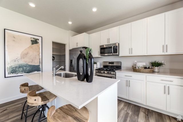 1803 E Bison Dr Unit B212, Eagle Mountain, UT 84005 - kitchen with stainless steel appliances, a sink, dark wood-type flooring, light stone counters, and white cabinetry