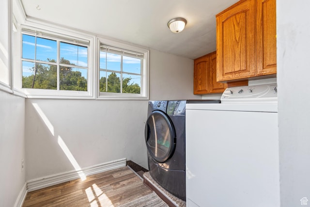 381 E 300 S, Logan, UT 84321 - laundry area featuring cabinet space, washer and dryer, wood finished floors, and baseboards