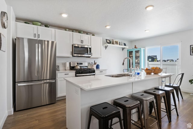 3547 E 1360 S, Spanish Fork, UT 84660 - kitchen with stainless steel appliances, a sink, dark wood-type flooring, a breakfast bar area, and white cabinets