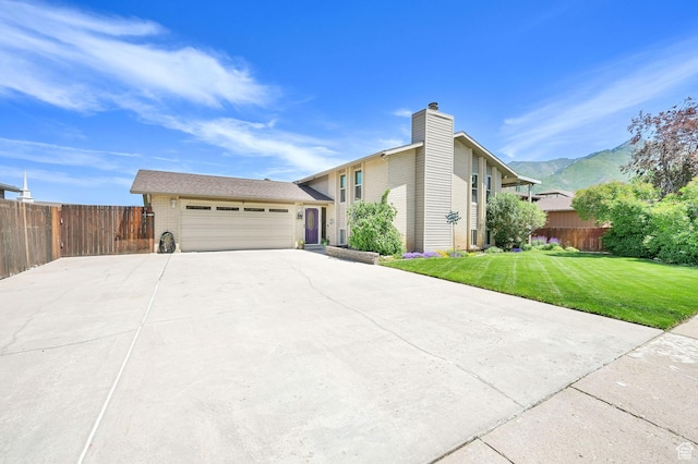 1368 E 5800 S, South Ogden, UT 84405 - view of front facade with an attached garage, concrete driveway, a mountain view, a chimney, and brick siding