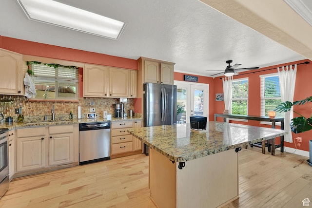 1368 E 5800 S, South Ogden, UT 84405 - kitchen featuring stainless steel appliances, light wood-style floors, decorative backsplash, a sink, and a center island