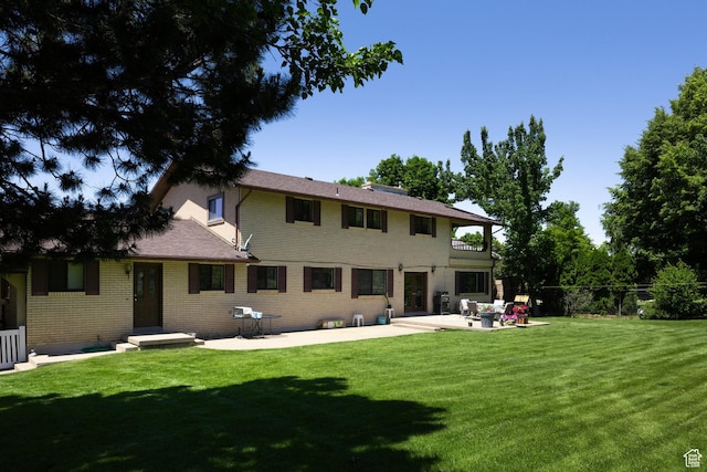 1478 N Ewe Turn St E, Kaysville, UT 84037 - back of property with a yard, a patio area, brick siding, and a balcony