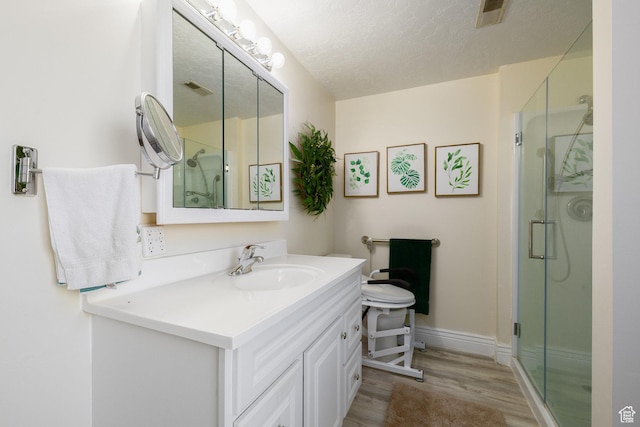 1478 N Ewe Turn St E, Kaysville, UT 84037 - bathroom featuring wood finished floors, vanity, a shower stall, baseboards, and a textured ceiling