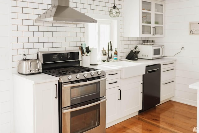 5363 E Cub Rd, Preston, ID 83263 - kitchen with double oven range, exhaust hood, dishwasher, white microwave, and decorative backsplash