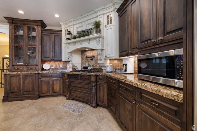 403 W 4000 S, Vernal, UT 84078 - kitchen featuring stainless steel microwave, dark brown cabinetry, arched walkways, backsplash, and gas stovetop