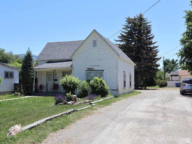 338 E 200 S Unit 338, Logan, UT 84321 - view of front of home with a shingled roof, covered porch, driveway, and a front lawn