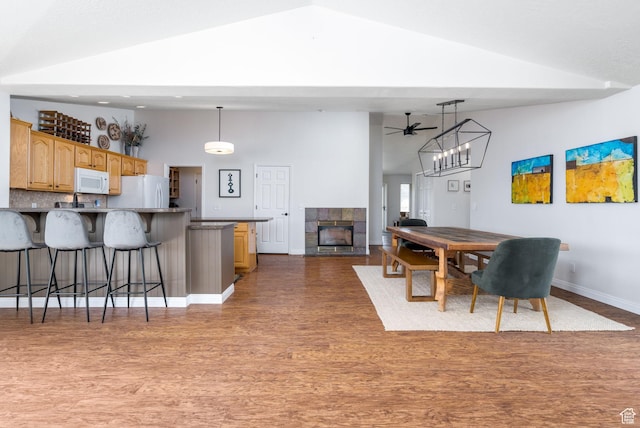 7850 Wasatch Way, Park City, UT 84098 - dining room featuring wood finished floors, ceiling fan, high vaulted ceiling, a tile fireplace, and baseboards