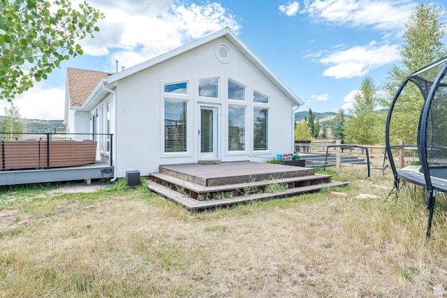 7850 Wasatch Way, Park City, UT 84098 - rear view of house with a trampoline, a deck with mountain view, and stucco siding