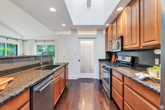 4055 N Cove Dr, Provo, UT 84604 - kitchen with appliances with stainless steel finishes, a sink, dark wood-style floors, backsplash, and dark stone countertops