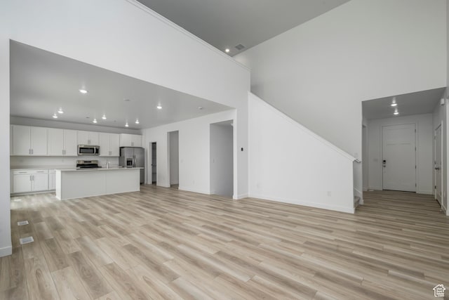 1847 E Badger Ave N Unit B253, Eagle Mountain, UT 84005 - unfurnished living room featuring recessed lighting, light wood-type flooring, baseboards, and stairway