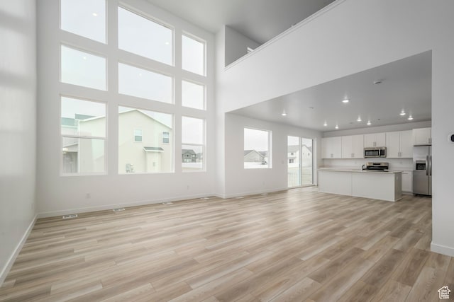 1847 E Badger Ave N Unit B253, Eagle Mountain, UT 84005 - unfurnished living room featuring light wood-style flooring, baseboards, and recessed lighting